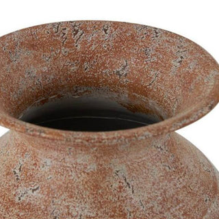 Top view of decorative metal vase opening showcasing terracotta interior and flared neck design