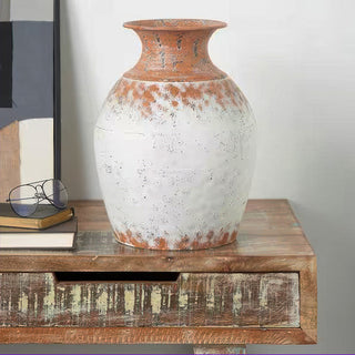 Large rustic white vase as centerpiece on wood table in modern farmhouse interior setting