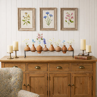  Eight terracotta clay vases on black iron stand styled on wooden sideboard