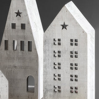 Two distressed white wooden village houses showing contrasting architectural styles with arched doorway and multi-story window designs