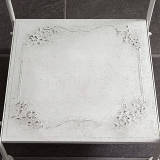 Decorative embossed floral detail on vintage washstand shelf