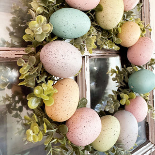 Close-up pastel Easter eggs wreath greenery